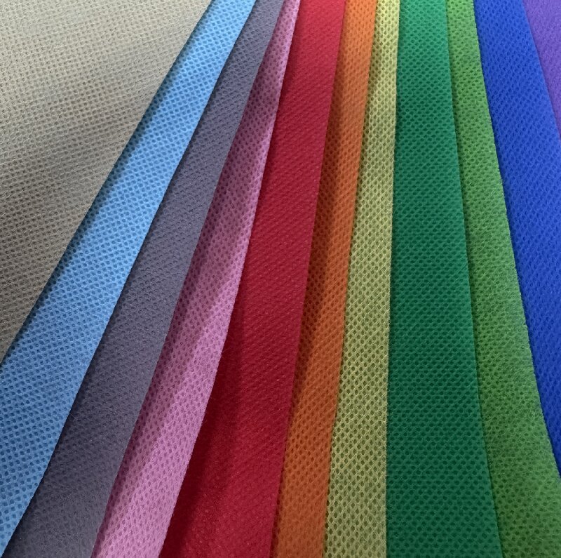 Рулоны цветного нетканого полипропиленового полотна плотностью 65 г/м² для изготовления прочных сумок.